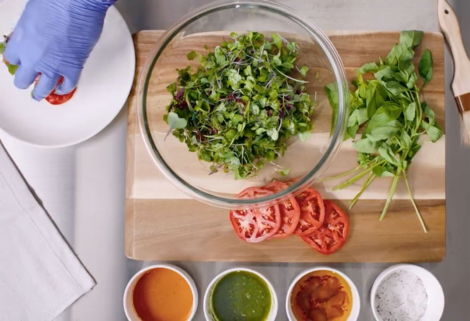Cutting board with lettuce, tomato and sauce ingredients.