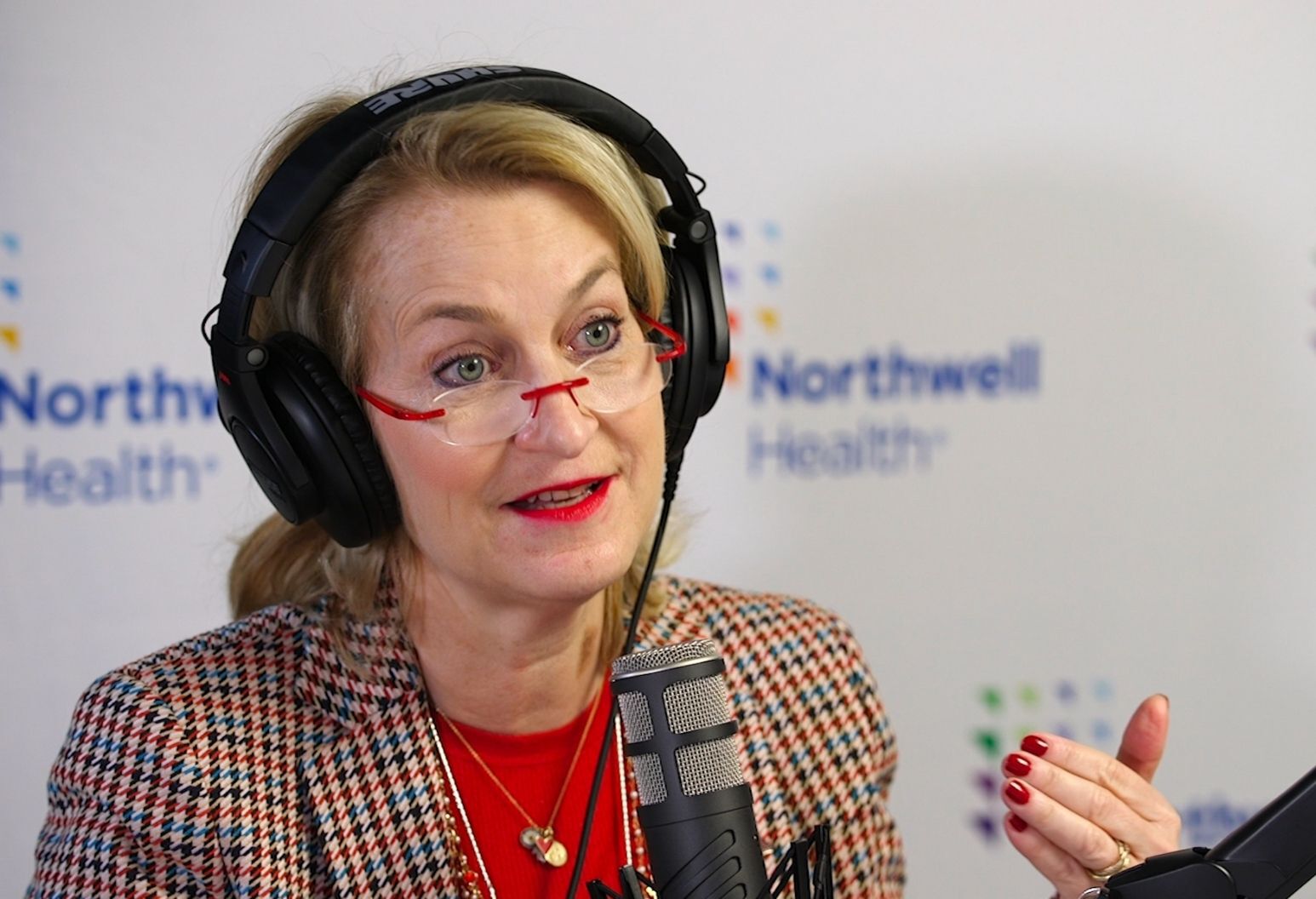 Woman wearing red glasses and headphones.