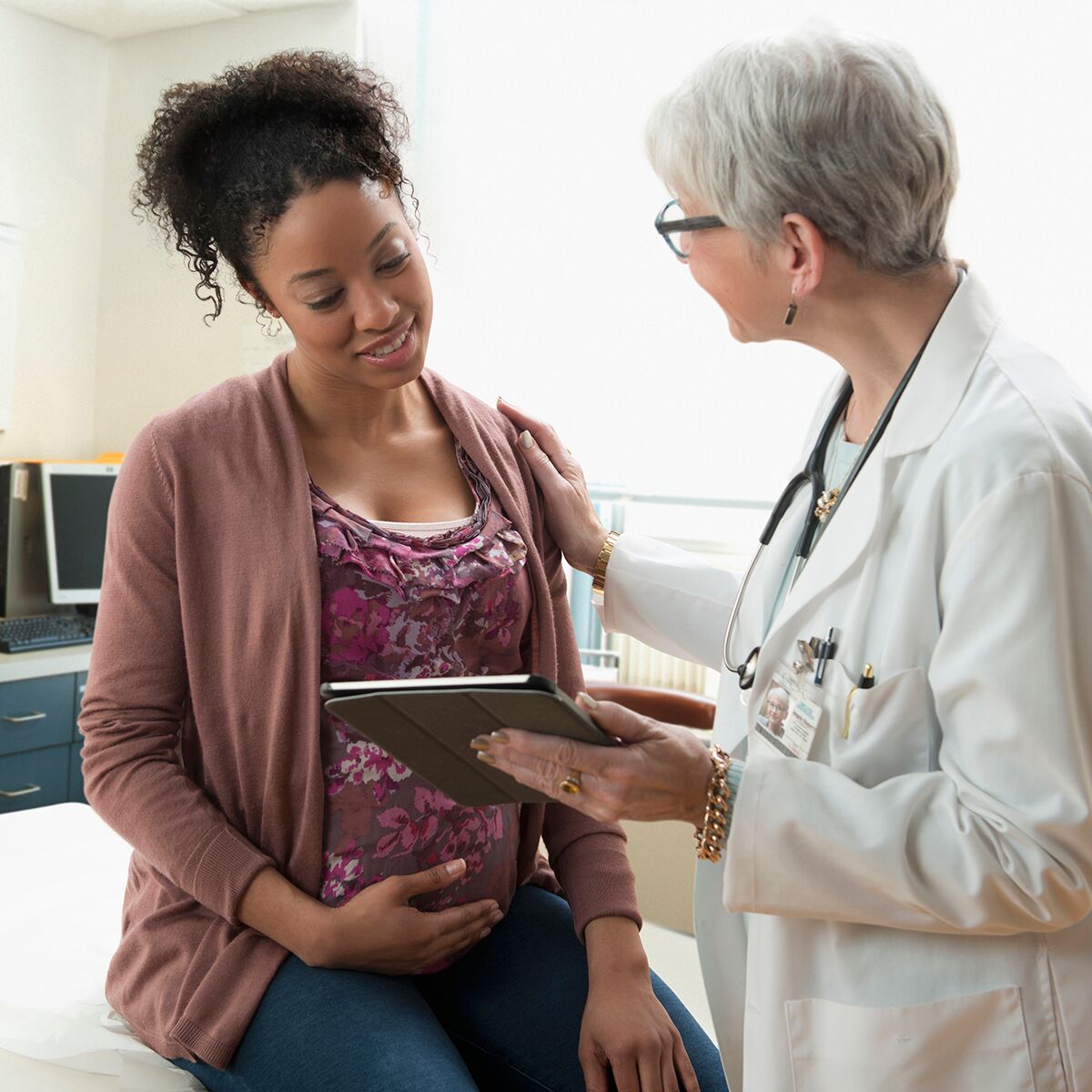 A woman doctor speaks to a black pregnant mother