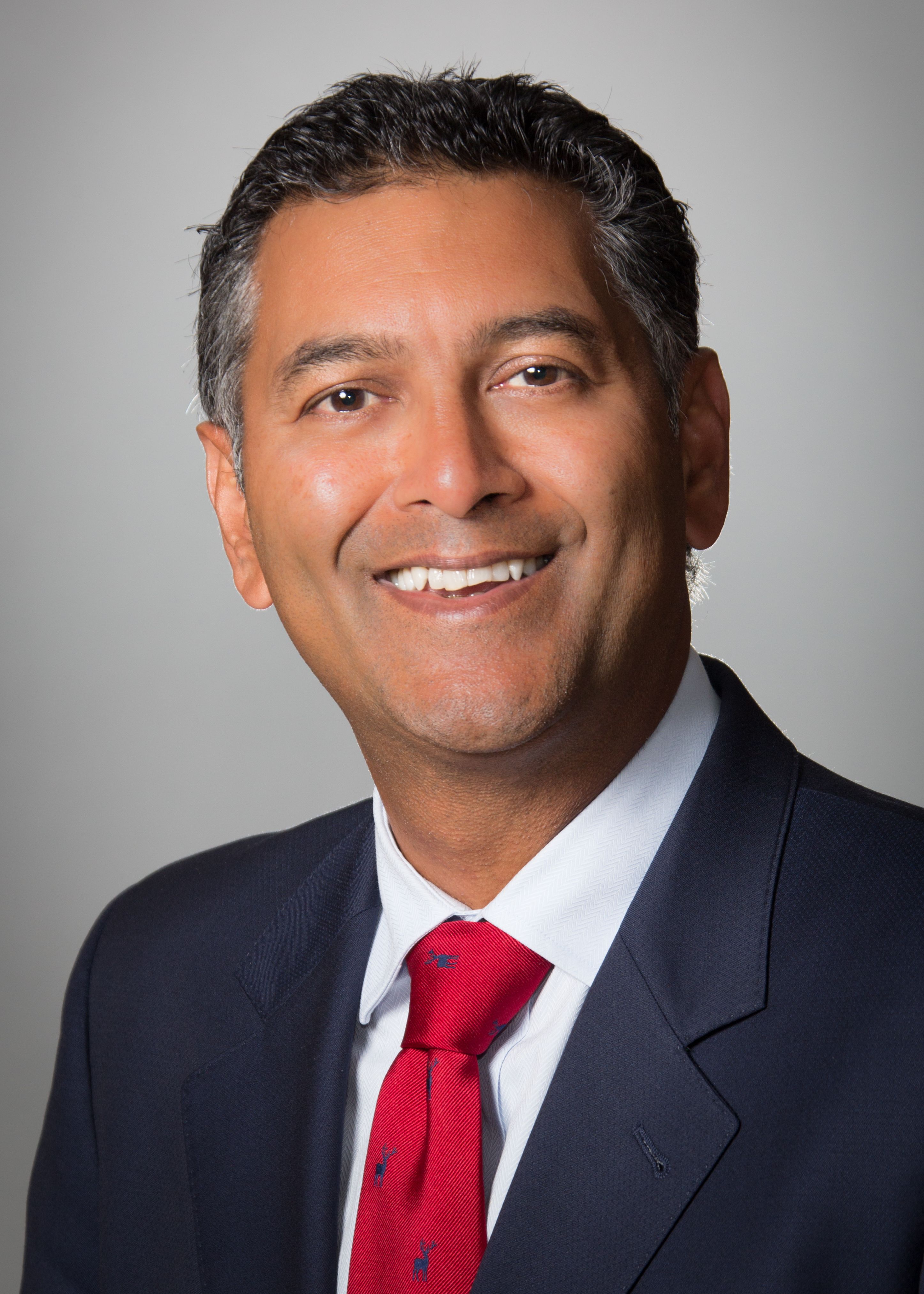 Varinder Singh, MD, wearing a suit and red tie