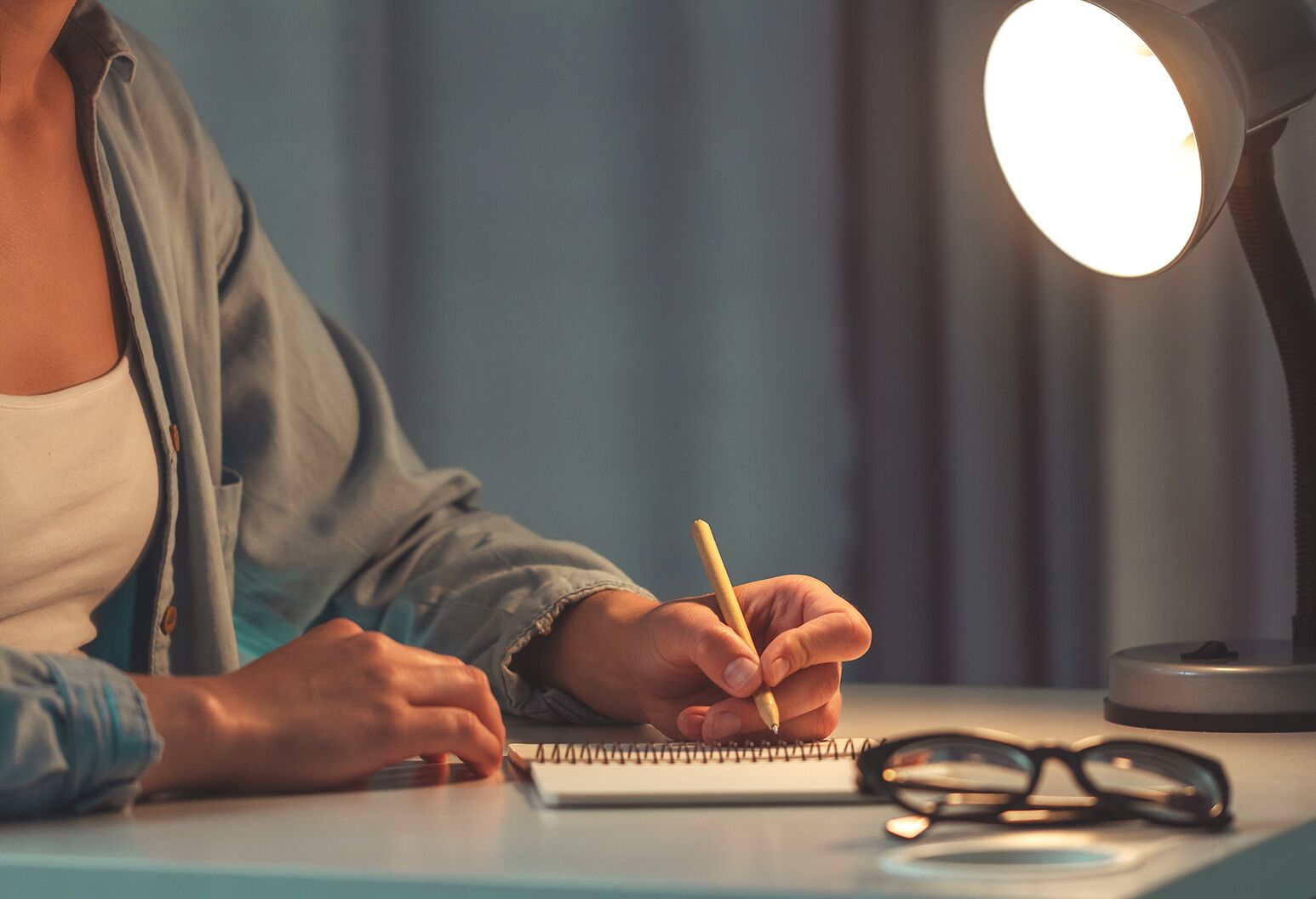 Person schreibt abends in Dankbarkeits-Journal