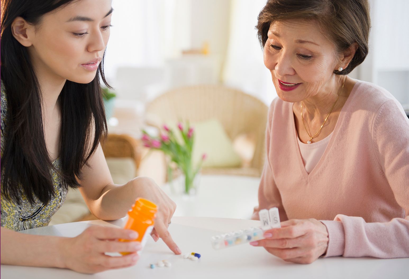 Daughter reviews prescription medications with her aging mother