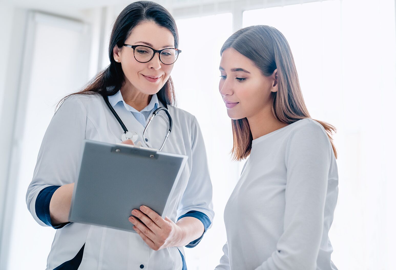 A doctor consulting with a young female patient.