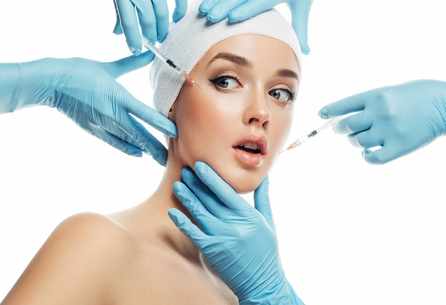  A woman with with a white cap on has the blue gloved hands holding her head still and injecting something into the sides of her face.