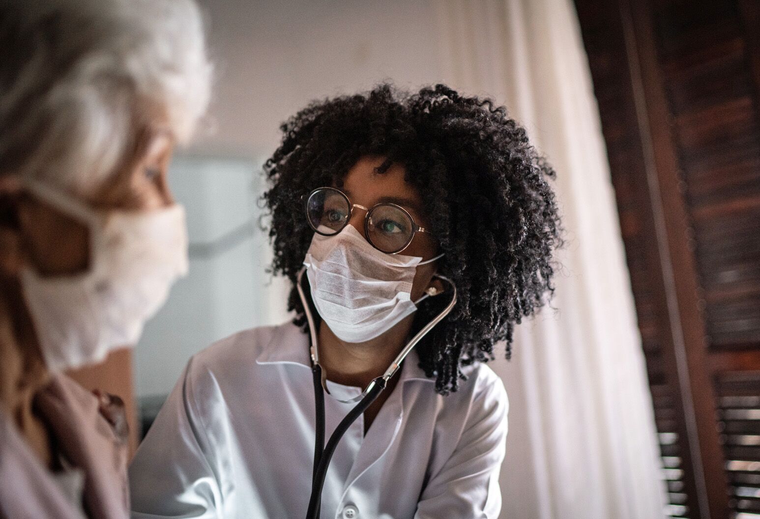 A female doctor listens to an elderly patient's heart. Jeffrey Kuvin, MD, discusses myocarditis and the lingering effects of COVID-19 on your heart.