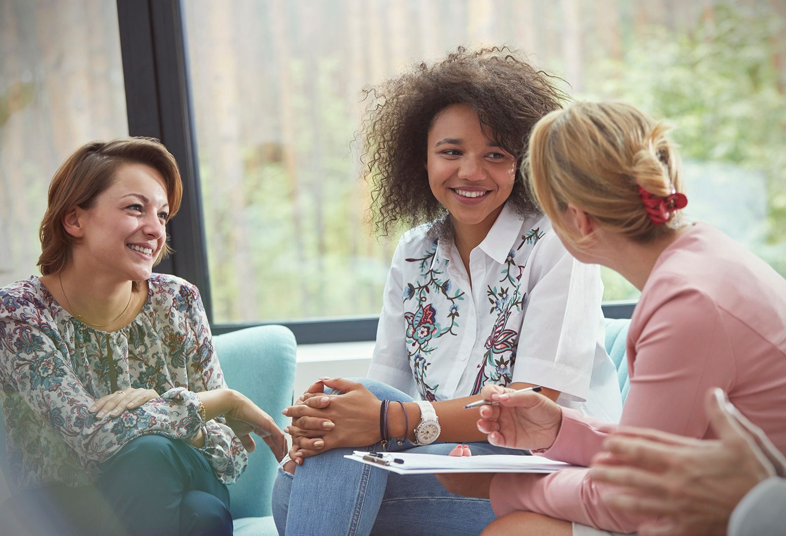 Smiling women talking in group therapy session