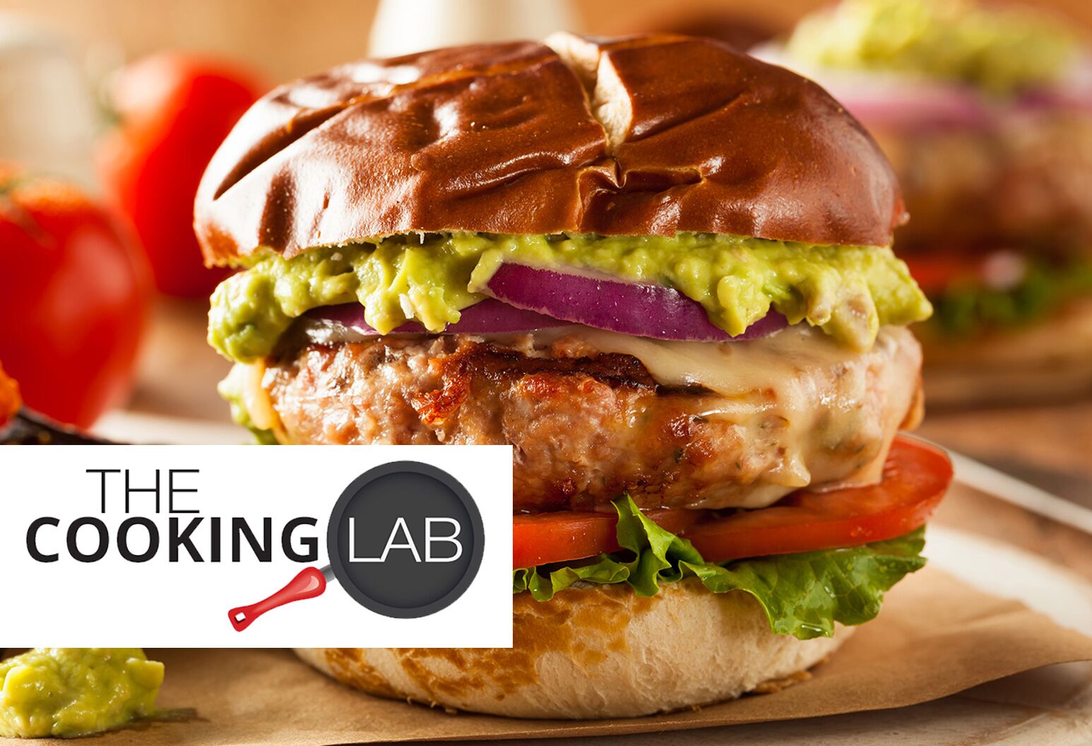 Turkey burger on a bun with lettuce, tomato, cheese, red onion, and guacamole is pictured on a wooden table.